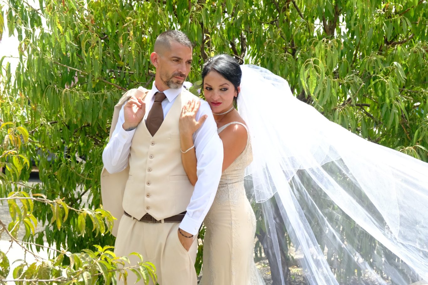 Reportajes de Boda en Capricolor Pareja vestida de boda, ella con velo y vestido claro, él con chaleco y corbata.- Capricolor
